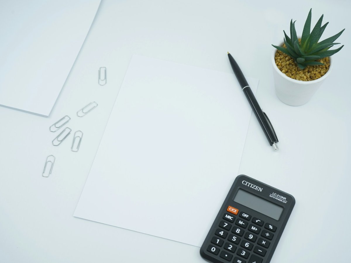 Escritorio con calculadora y planta para análisis de inversión